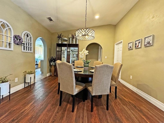 dining space featuring dark hardwood / wood-style floors and vaulted ceiling