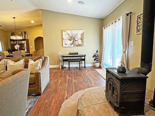 living room featuring a wood stove, lofted ceiling, and dark hardwood / wood-style floors