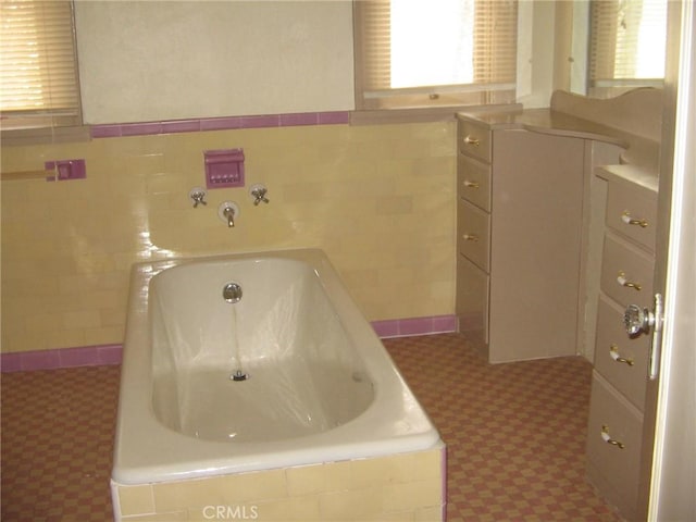 bathroom with tile walls and tiled tub