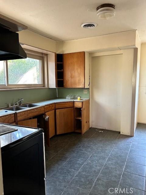 kitchen featuring dark tile patterned flooring, electric stove, and sink