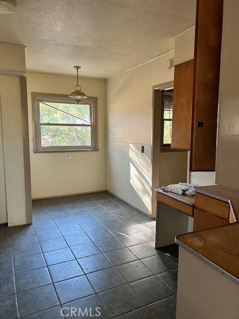 unfurnished dining area featuring dark tile patterned floors