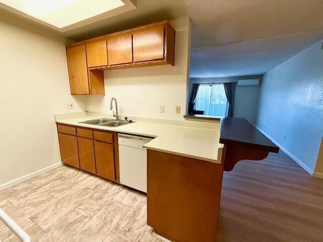 kitchen with dishwasher, sink, and a wall mounted air conditioner