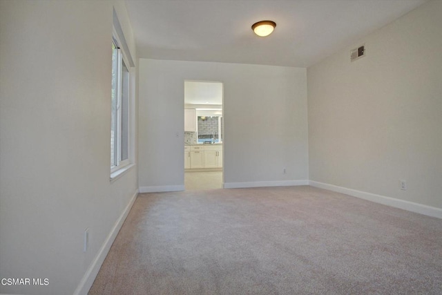 unfurnished room featuring light carpet