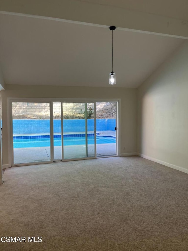 empty room featuring a water view, vaulted ceiling with beams, plenty of natural light, and carpet flooring