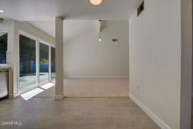 unfurnished room with light carpet and vaulted ceiling