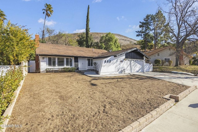 ranch-style house with a front yard, a garage, and a mountain view