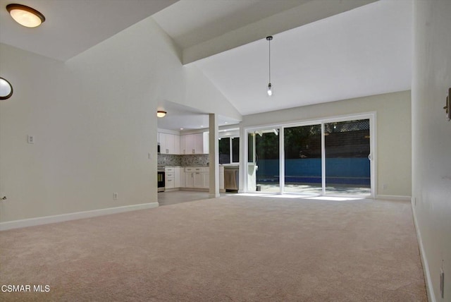 unfurnished living room featuring high vaulted ceiling and light colored carpet