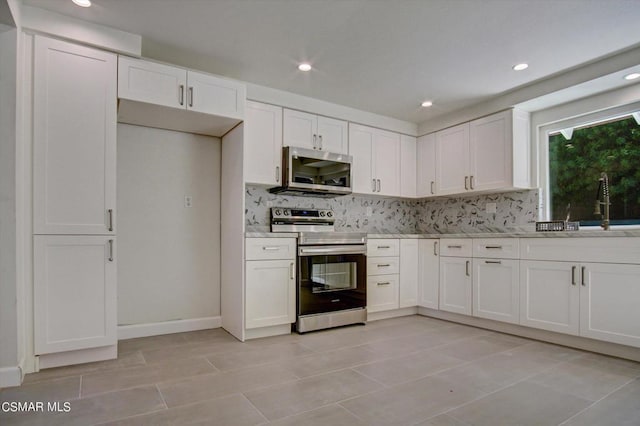 kitchen featuring backsplash, appliances with stainless steel finishes, and white cabinetry