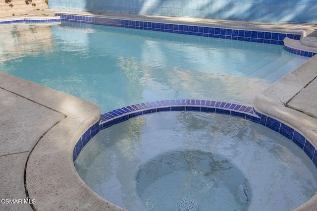 view of pool featuring an in ground hot tub