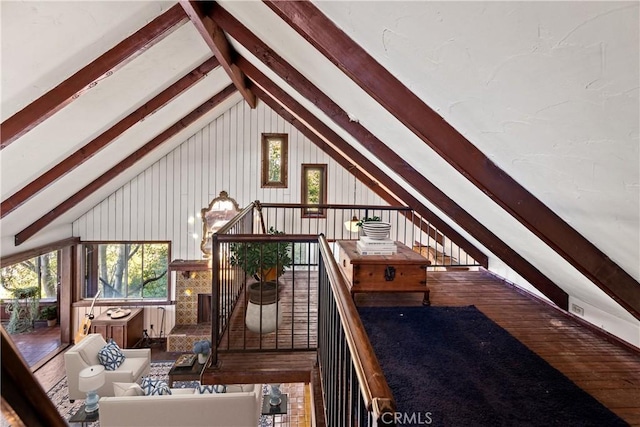 living room featuring vaulted ceiling with beams, wood-type flooring, and wooden walls