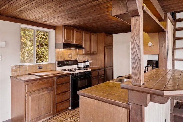 kitchen featuring kitchen peninsula, backsplash, white gas range, wooden ceiling, and tile counters