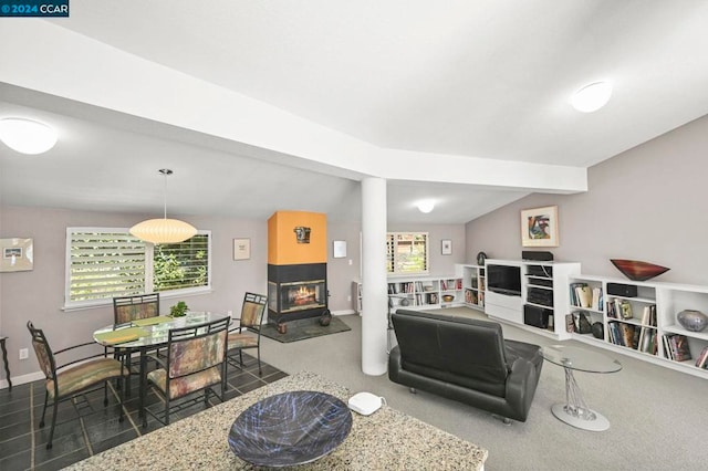 living room with a multi sided fireplace and lofted ceiling with beams