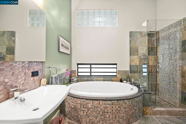 bathroom featuring shower with separate bathtub and sink