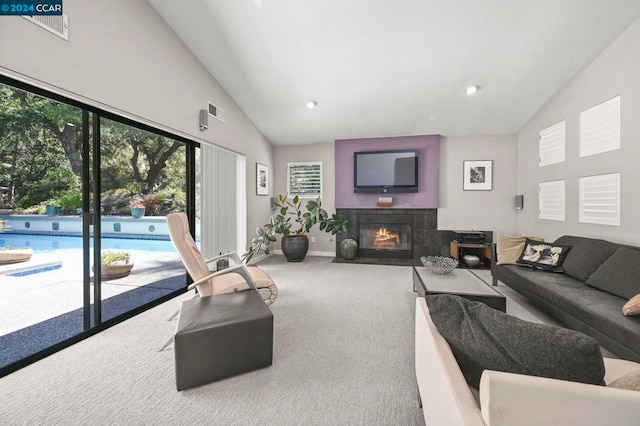 carpeted living room featuring lofted ceiling and a tile fireplace