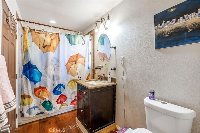 bathroom with a shower with curtain, hardwood / wood-style floors, vanity, and toilet