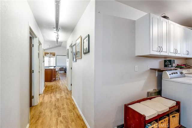 hallway with washing machine and clothes dryer, lofted ceiling, and light hardwood / wood-style flooring