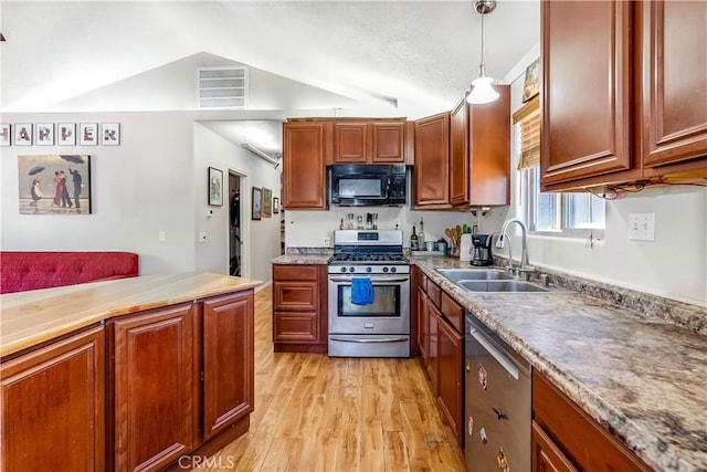 kitchen featuring sink, stainless steel appliances, light hardwood / wood-style flooring, vaulted ceiling, and decorative light fixtures