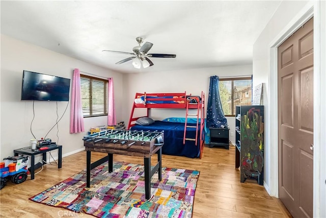 bedroom featuring multiple windows, ceiling fan, and hardwood / wood-style floors