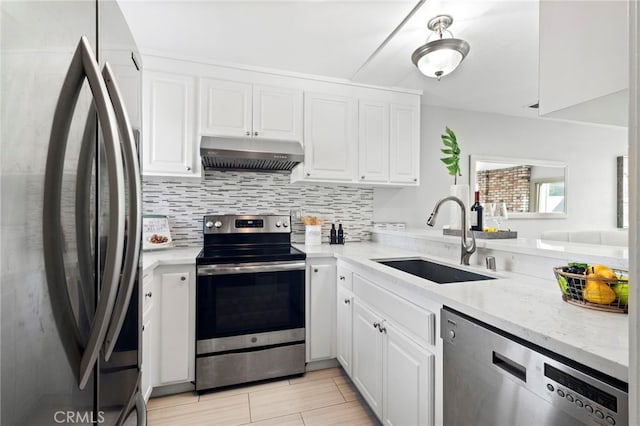 kitchen with light stone counters, sink, tasteful backsplash, white cabinetry, and stainless steel appliances