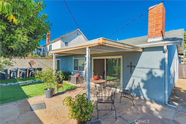 rear view of house featuring a patio and a yard