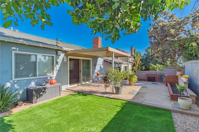 rear view of property featuring a lawn and a patio