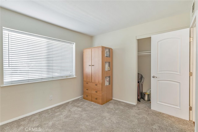 unfurnished bedroom featuring light carpet and a closet