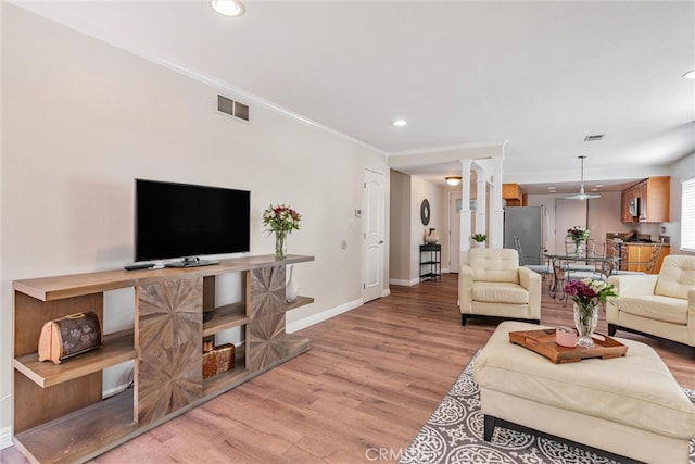 living room with light hardwood / wood-style flooring and crown molding