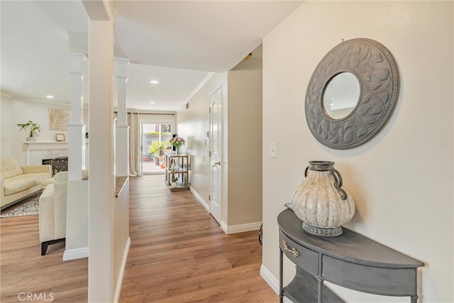 hall with light hardwood / wood-style flooring and crown molding