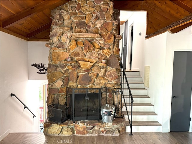 interior space featuring a stone fireplace, wooden ceiling, vaulted ceiling with beams, and hardwood / wood-style flooring