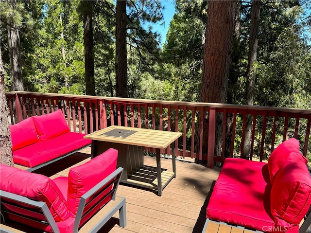 wooden deck with an outdoor living space with a fire pit