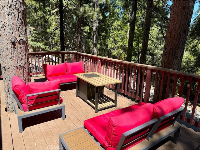 wooden deck with an outdoor living space with a fire pit