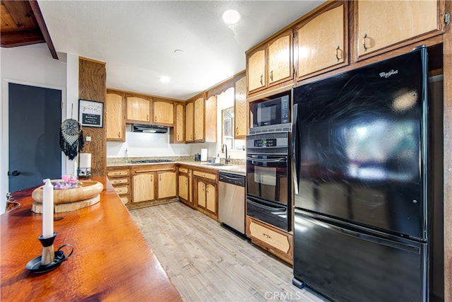 kitchen featuring light hardwood / wood-style flooring, beam ceiling, black appliances, and sink