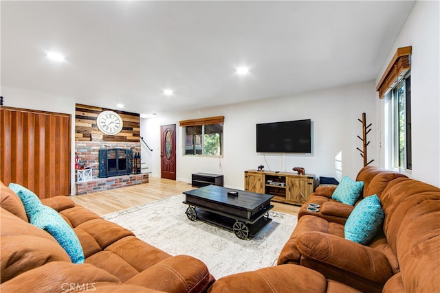 living room with hardwood / wood-style flooring, a wealth of natural light, and a fireplace