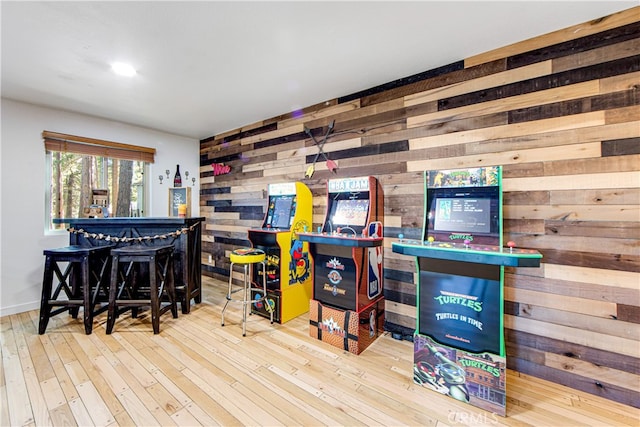 recreation room with hardwood / wood-style flooring and wood walls