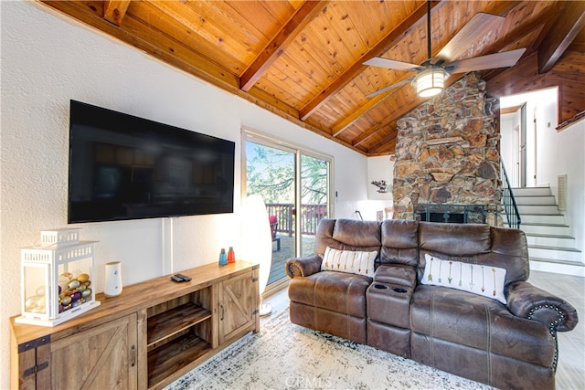 living room with ceiling fan, wood ceiling, vaulted ceiling with beams, and a fireplace