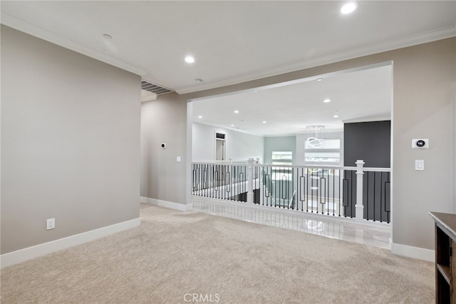 carpeted spare room with crown molding and an inviting chandelier