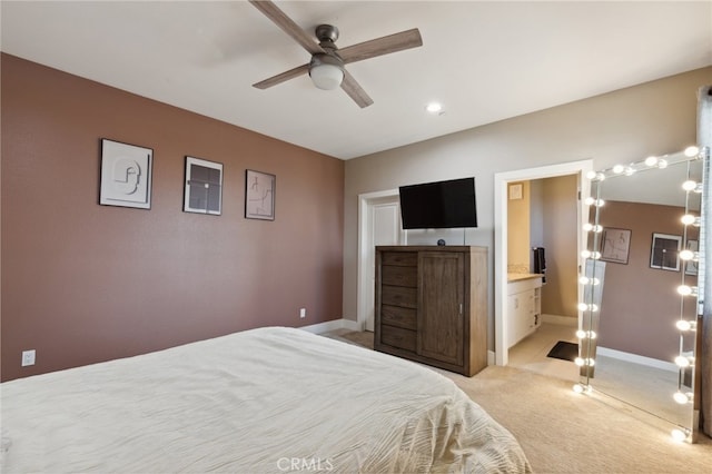 bedroom featuring ceiling fan, light colored carpet, and ensuite bathroom