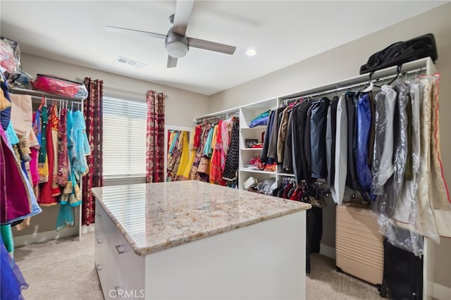 spacious closet featuring ceiling fan and light colored carpet