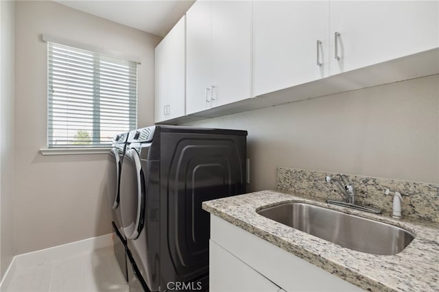 washroom with washer and clothes dryer, cabinets, and sink