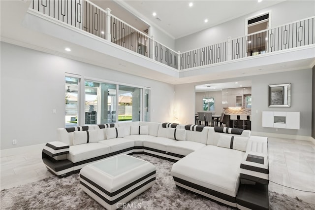 tiled living room with a towering ceiling and ornamental molding