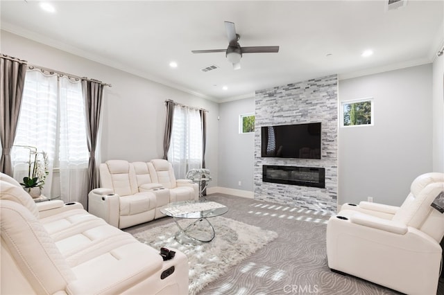 carpeted living room with ceiling fan, a fireplace, and crown molding