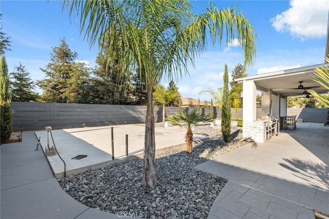 view of yard with ceiling fan and a patio area