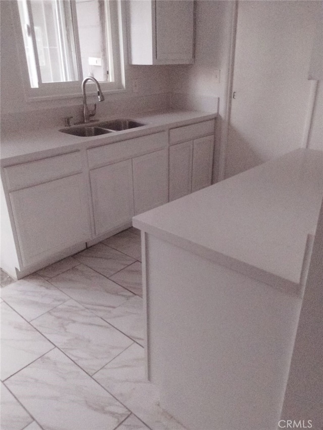 kitchen featuring sink and white cabinetry