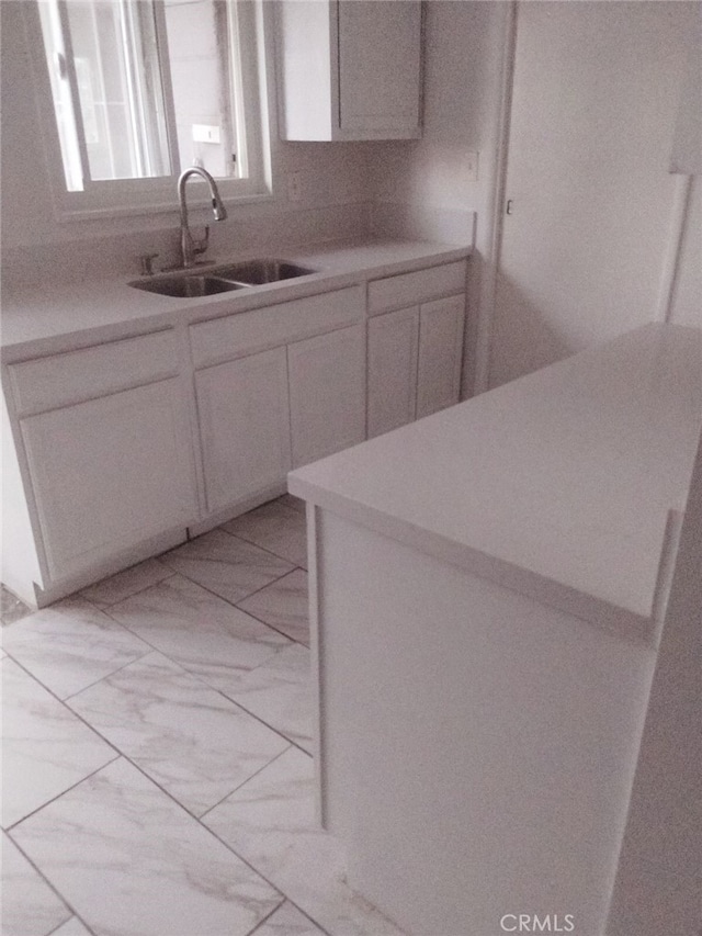 kitchen featuring sink and white cabinetry