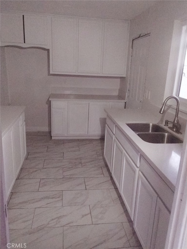 kitchen featuring white cabinetry and sink