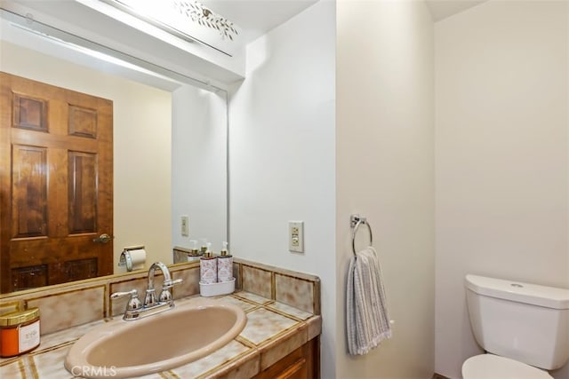 bathroom featuring vanity and toilet