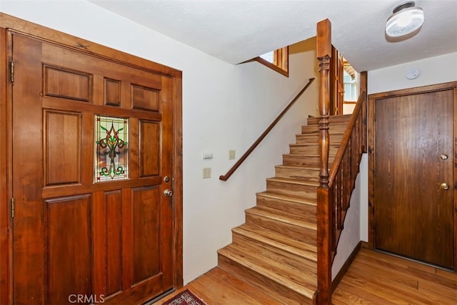 entryway with light hardwood / wood-style flooring and a textured ceiling