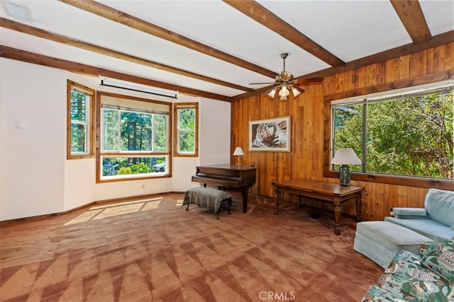 interior space featuring carpet, a wall mounted air conditioner, wooden walls, ceiling fan, and beamed ceiling