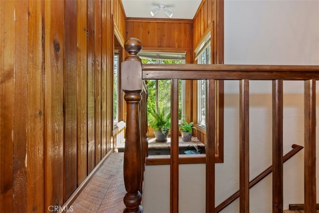 stairs featuring ceiling fan and wooden walls