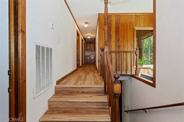 stairs with wood walls and wood-type flooring